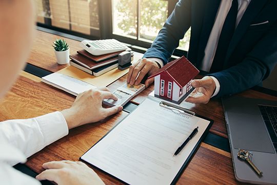 Zwei Menschen am Schreibtisch bei Verhandlung zum Kaufvertrag in der Südoststeiermark